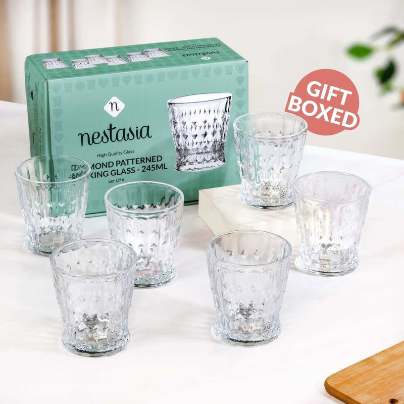 Set of clear patterned glass tumblers with a Nestasia branded box on a white surface.
